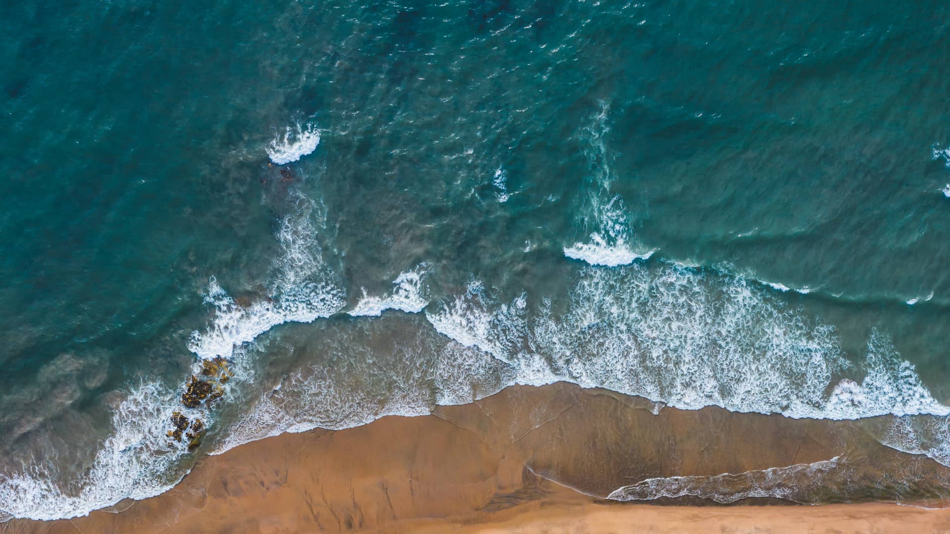 vertical-bird-eye-shot-beach-with-blue-sea (1) (1) (1)
